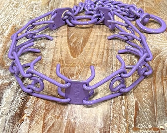 May include: Purple prong collar for dogs with a chain link attachment. The collar is made of metal and has a  "SHOCK" label on the side.