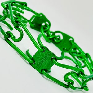 Puede incluir: Collar de púas de metal verde para perros. El collar tiene una etiqueta cuadrada que dice "Gentle Leader".