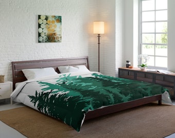 May include: A white and green duvet cover with a forest print. The duvet cover is on a bed with a wooden frame and a brown rug.