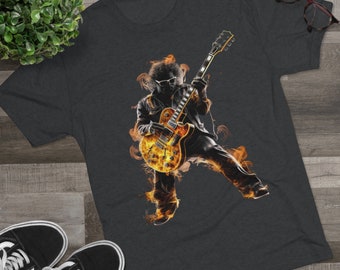May include: A dark grey t-shirt with a graphic of a person playing a yellow electric guitar with flames behind them.