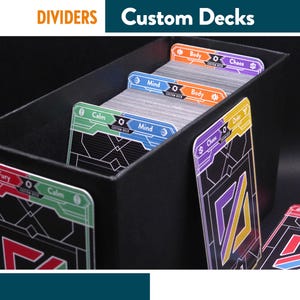 Pode incluir: Caixa de cartas preta com divisórias rotuladas "Fury", "Calm", "Mind", "Body" e "Chaos". As divisórias são codificadas por cores: vermelho, verde, azul, laranja e roxo. O texto "Custom Decks" está no topo.