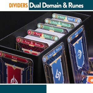 Pode incluir: Caixa preta com divisórias de cartas com as etiquetas "Fury", "Calm" e "Mind", e o texto "Dual Domain & Runes". As divisórias separam baralhos de cartas com costas ilustradas em vermelho, verde e azul. Os cartões têm detalhes dourados e brancos.