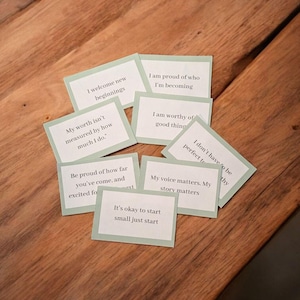 Op de afbeelding: Een verzameling kleine kaarten met inspirerende citaten, omlijst door lichtgroen. De kaarten bevatten zinnen als 'Ik verwelkom nieuwe beginnen' en 'Mijn stem doet ertoe. Mijn verhaal doet ertoe.'