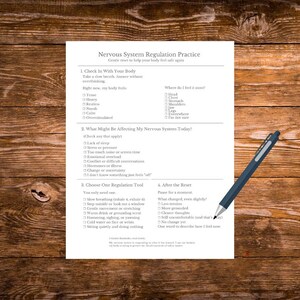 Op de afbeelding: Een wit vel papier met de titel "Nervous System Regulation Practice" en een blauwe pen op een houten oppervlak. Het papier bevat een checklist voor zelfevaluatie en regulatietechnieken.