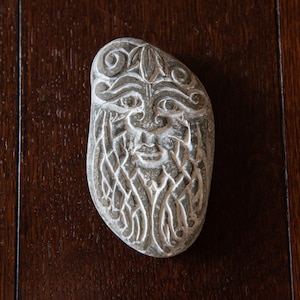 Green man with a beard as a Celtic braided ornament