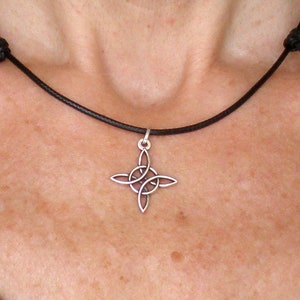 Op de afbeelding: Een zilveren Keltische knoop hanger ketting op een zwart leren koord.