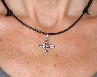 May include: A silver Celtic knot pendant necklace on a black leather cord.
