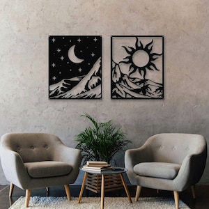 Puede incluir: Dos piezas de arte de pared de metal negro que representan una cordillera con una luna creciente y estrellas en una pieza y un sol en la otra.