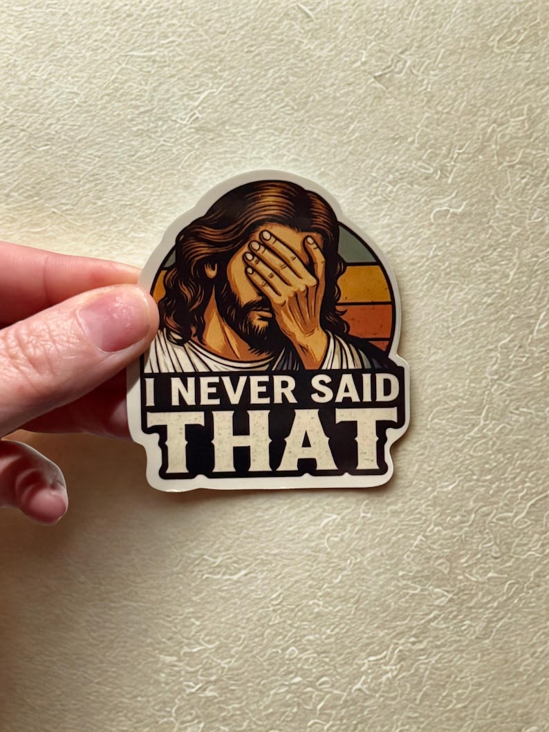 May include: A sticker featuring an illustration of a person with long hair and a beard, covering their eyes with their hand. The text "I NEVER SAID THAT" is displayed in bold, black letters.