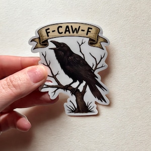 Op de afbeelding: Een sticker met een zwarte kraai op een tak. Boven de kraai staat een banner met de tekst "F-CAW-F". De sticker heeft een witte achtergrond. De kraai en de banner zijn in cartoonstijl.