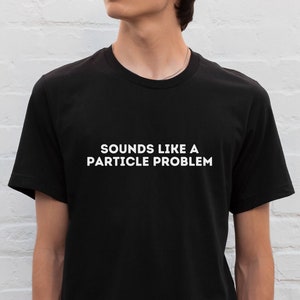 May include: A black t-shirt with white text that reads "Sounds like a particle problem."