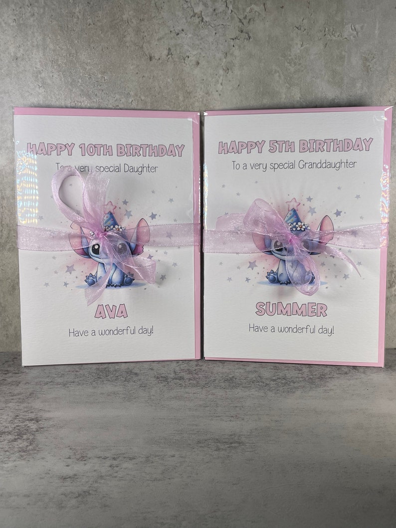 May include: Two pink birthday cards with a blue cartoon character wearing a party hat. The card on the left says "Happy 10th Birthday To a very special Daughter Ava Have a wonderful day!" The card on the right says "Happy 5th Birthday To a very special Granddaughter Summer Have a wonderful day!"
