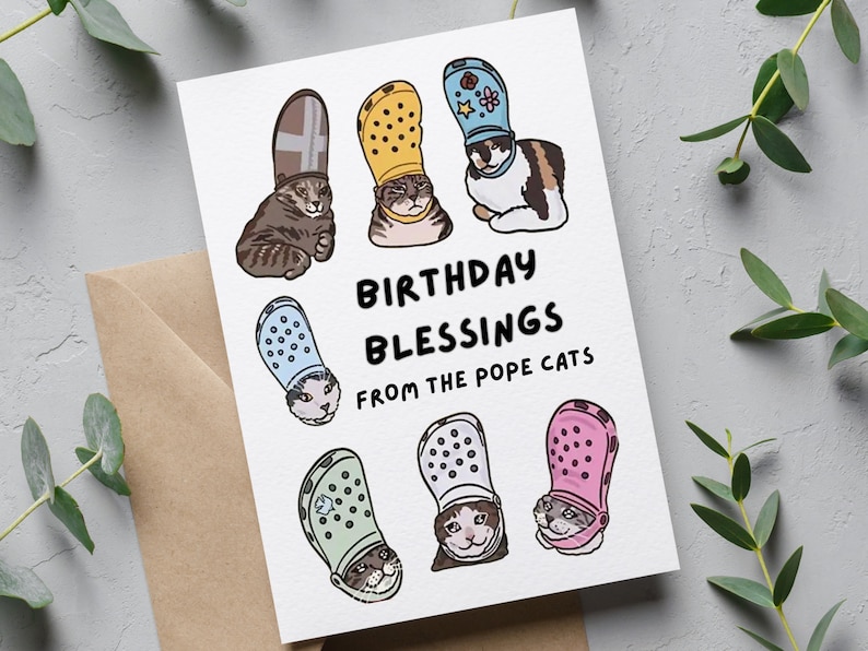 Puede incluir: Una tarjeta de felicitaci&oacute;n con una ilustraci&oacute;n humor&iacute;stica de gatos que llevan Crocs coloridos como sombreros. El texto dice "Birthday Blessings from the Pope Cats".