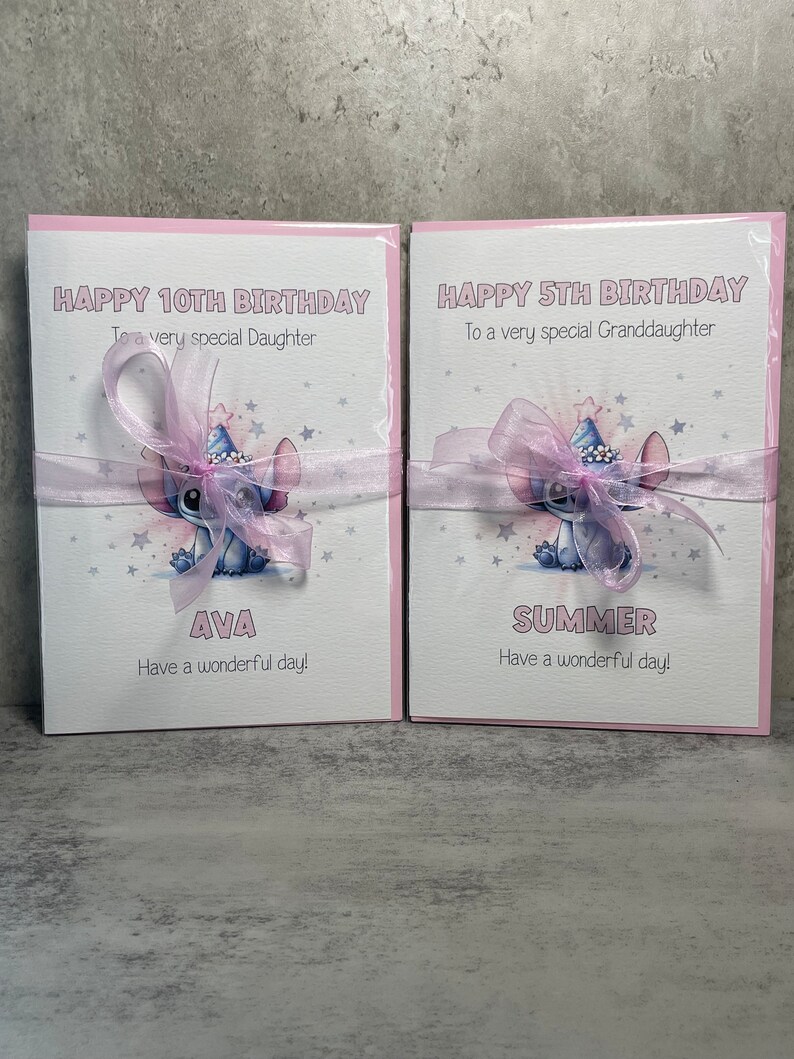 May include: Two pink birthday cards with a blue cartoon character wearing a party hat. The card on the left says "Happy 10th Birthday To a very special Daughter Ava Have a wonderful day!" The card on the right says "Happy 5th Birthday To a very special Granddaughter Summer Have a wonderful day!"