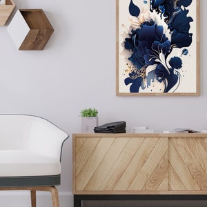 May include: A framed abstract art print with a white background and a blue and gold floral design. The print is hanging on a white wall above a wooden cabinet.