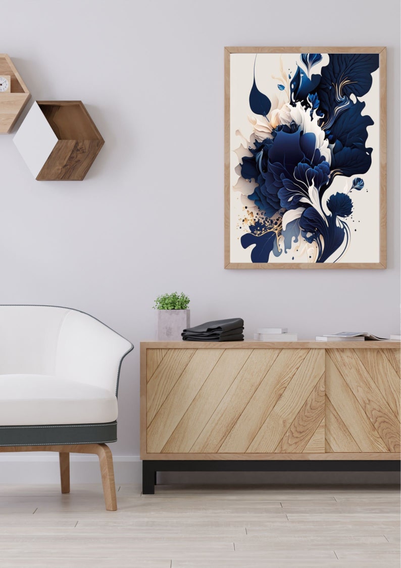 May include: A framed abstract art print with a white background and a blue and gold floral design. The print is hanging on a white wall above a wooden cabinet.