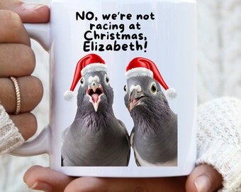 May include: White ceramic mug with a black and white image of two pigeons wearing Santa hats. The text on the mug reads "NO, we're not racing at Christmas, Elizabeth!"