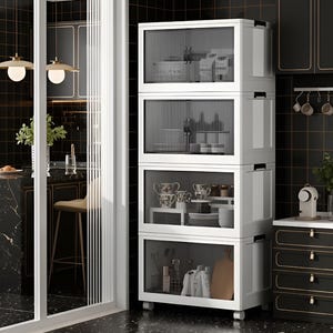 May include: A white, four-tiered storage cabinet with clear, ribbed glass doors. The cabinet is filled with kitchen items, including dishes and utensils. The cabinet is on wheels and is set against a black tiled wall. The kitchen has a modern design.