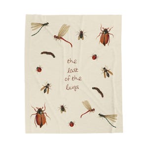 May include: A cream-colored throw blanket featuring watercolor illustrations of various insects, including dragonflies, beetles, and ladybugs. The text "the last of the bugs" is written in a handwritten font.