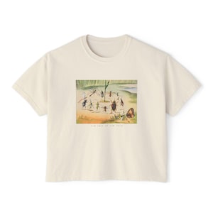 Puede incluir: Camiseta color crema con una colorida ilustración de varios insectos reunidos alrededor de una pequeña bandera. El texto "the last of the hare" está impreso debajo de la imagen. La camiseta tiene cuello redondo y mangas cortas.