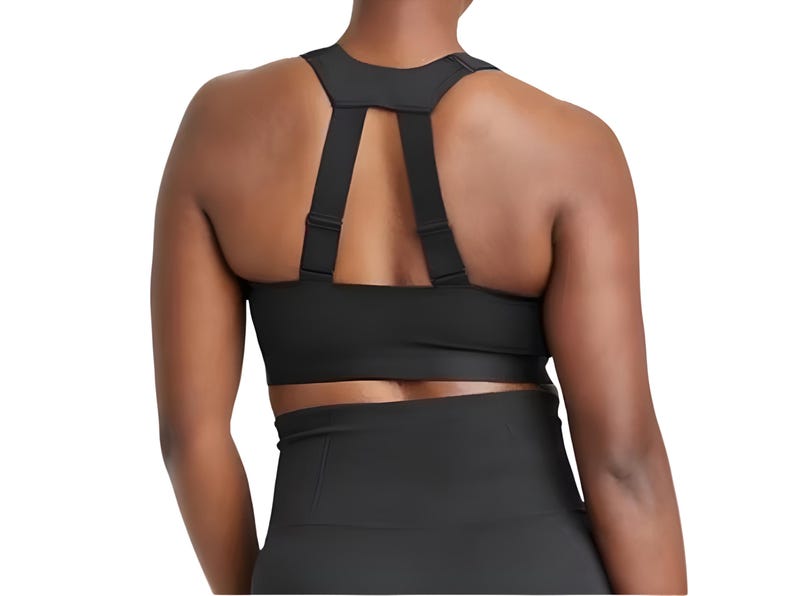 Puede incluir: Sujetador deportivo negro con tirantes ajustables y un dise&ntilde;o de soporte. El sujetador presenta un estilo de espalda deportiva con una banda ancha debajo del busto para mayor soporte. La tela parece ser un material suave y atl&eacute;tico.