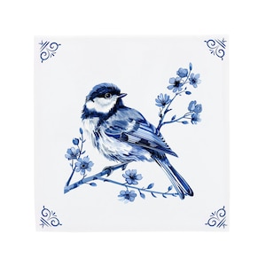 Könnte beinhalten: Eine blaue und weiße Keramikfliese mit einem blauen Vogel, der auf einem Zweig mit blauen Blüten sitzt. Die Fliese hat einen weißen Hintergrund und blaue dekorative Ränder.