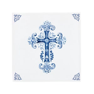 Puede incluir: Un azulejo de cerámica blanco con un diseño de cruz azul y blanco. La cruz es ornamentada y tiene un patrón floral. El azulejo tiene un borde simple.