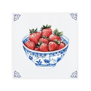 Op de afbeelding: Een blauwe en witte porseleinen kom gevuld met rode aardbeien. De kom heeft een bloemmotief.