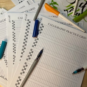 May include: A stack of calligraphy practice grids with a chequered pattern and lines. The grids are white with black lines. There are several pens on top of the grids, including a blue pen, a silver pen, and a yellow pen.
