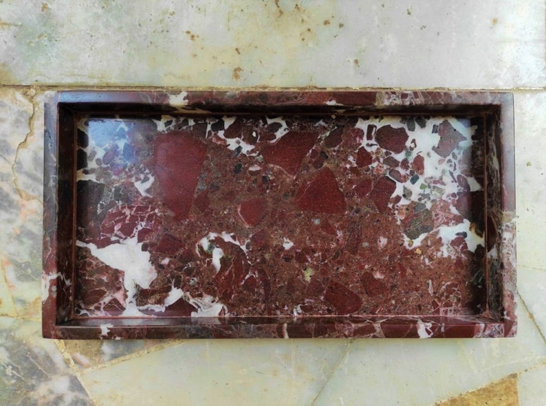 May include: A rectangular marble tray with a dark red and white marbled pattern. The tray has a raised rim.
