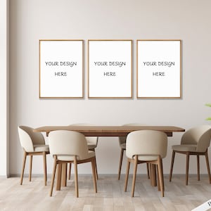 Könnte beinhalten: Drei gerahmte Drucke mit dem Text "Your Design Here" hängen an einer weißen Wand über einem Esstisch aus Holz mit vier beigen Stühlen.