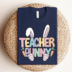 May include: A navy blue t-shirt with a colorful graphic of a bunny with the text "Teacher Bunny".