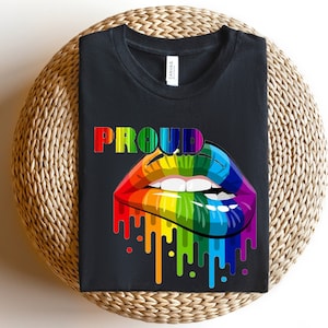 May include: Black t-shirt with the word "PROUD" in rainbow letters and a rainbow dripping lips graphic.