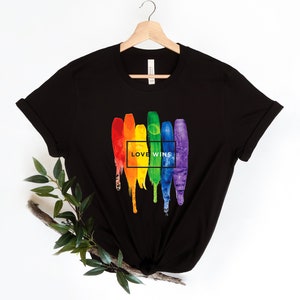 May include: Black t-shirt with a rainbow paintbrush design and the text "LOVE WINS" in a white box.