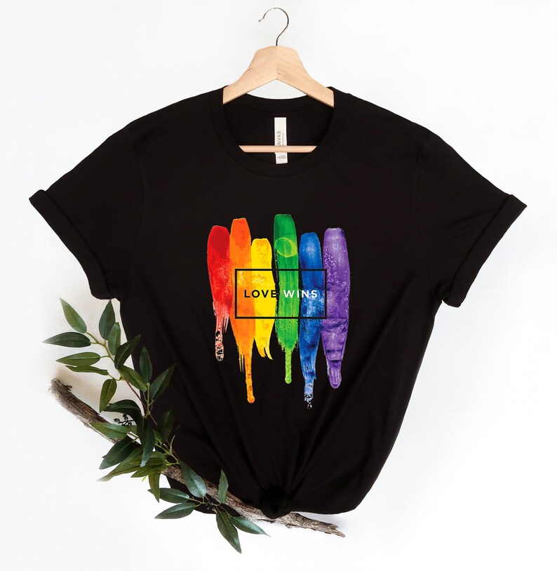 May include: Black t-shirt with a rainbow paintbrush design and the text "LOVE WINS" in a white box.