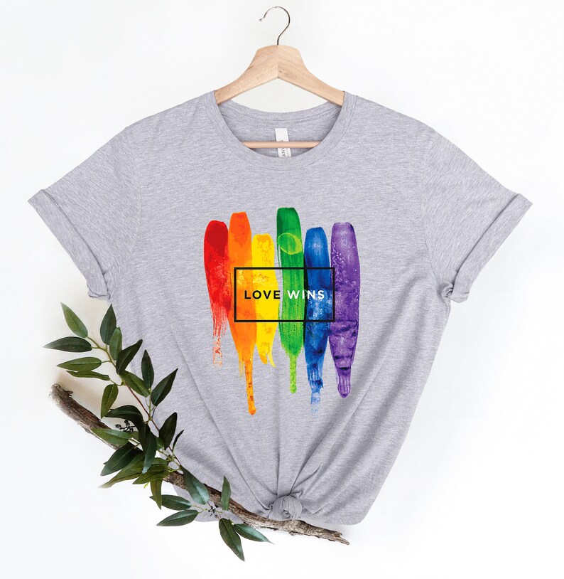 May include: Gray t-shirt with a rainbow paint splatter design and the text "LOVE WINS" in a black box.