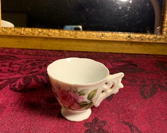 Vintage tiny teacup with beautiful ornate handle.