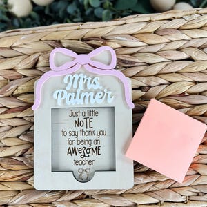 May include: A wooden sign with a pink bow and the text "Mrs. Palmer" at the top. The sign has a cutout in the middle with the text "Just a little NOTE to say thank you for being an AWESOME teacher".