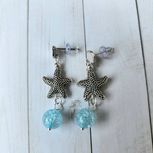 Starfish stud earrings with blue glass bead
