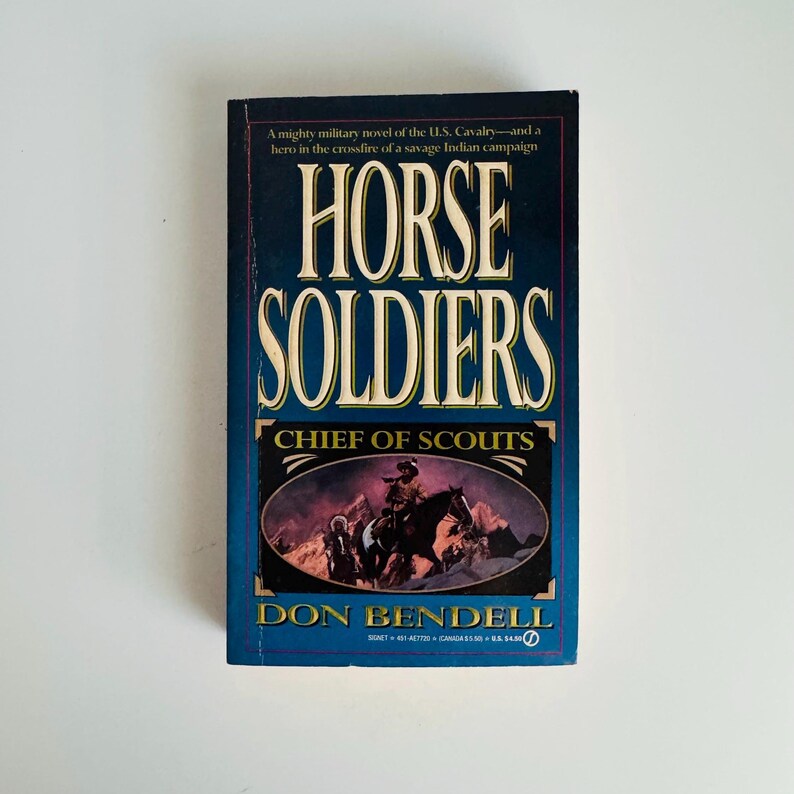 Pu&ograve; includere: Un libro tascabile intitolato "HORSE SOLDIERS" di Don Bendell. La copertina &egrave; prevalentemente blu con scritte bianche e dorate. Il sottotitolo del libro &egrave; "CHIEF OF SCOUTS" e presenta un'illustrazione di cavalieri in un paesaggio montuoso.
