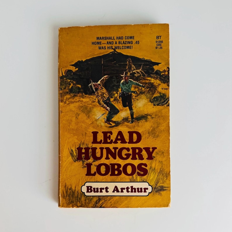 Pu&ograve; includere: Libro tascabile vintage intitolato "Lead Hungry Lobos" di Burt Arthur. La copertina presenta un'illustrazione a tema western di due cowboy e il testo "Marshall had come home and a blazing .45 was his welcome!"