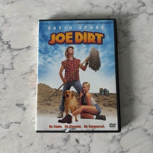 May include: A DVD case for the movie "Joe Dirt" featuring David Spade. The cover art shows Spade holding a mop, with a woman and a dog. The title is in large, colorful letters against a blue sky background.