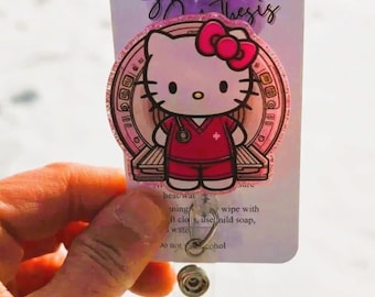 May include: Pink Hello Kitty badge reel with a sparkly pink background. The Hello Kitty character is wearing a pink and red nurse uniform. The text "Sparkled Thesis" is visible on the card behind the badge reel.
