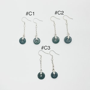 Könnte beinhalten: Drei Paar silberne Ohrringe mit dunkelgrünen Jade-Steinen als Anhänger. Die Ohrringe sind mit #C1, #C2 und #C3 gekennzeichnet.