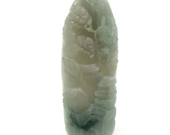 Puede incluir: Un colgante de jade tallado con un esquema de color verde y blanco. El colgante presenta intrincados detalles de un dragón y otras criaturas míticas.