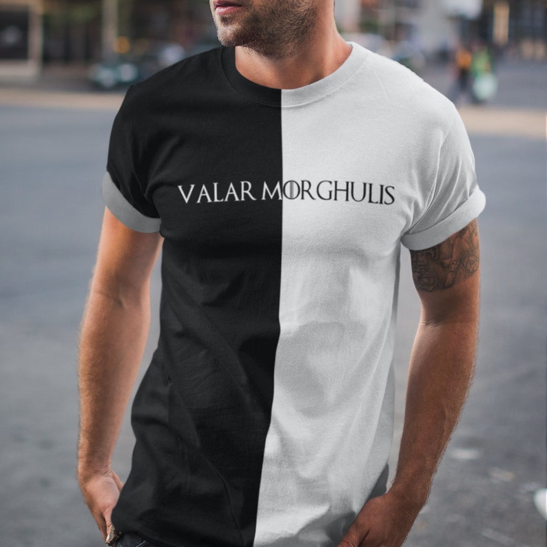 May include: A black and white t-shirt with the text "Valar Morghulis" printed in white on the black side of the shirt.