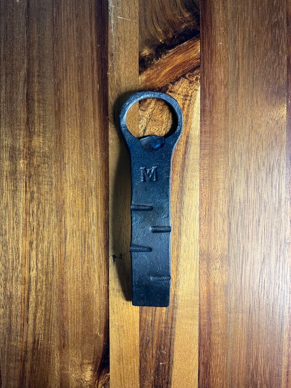 A blacksmith actually hammered this bottle opener from raw steel — the kind of simple, forever-useful object that feels totally different from anything you'd buy at a store.