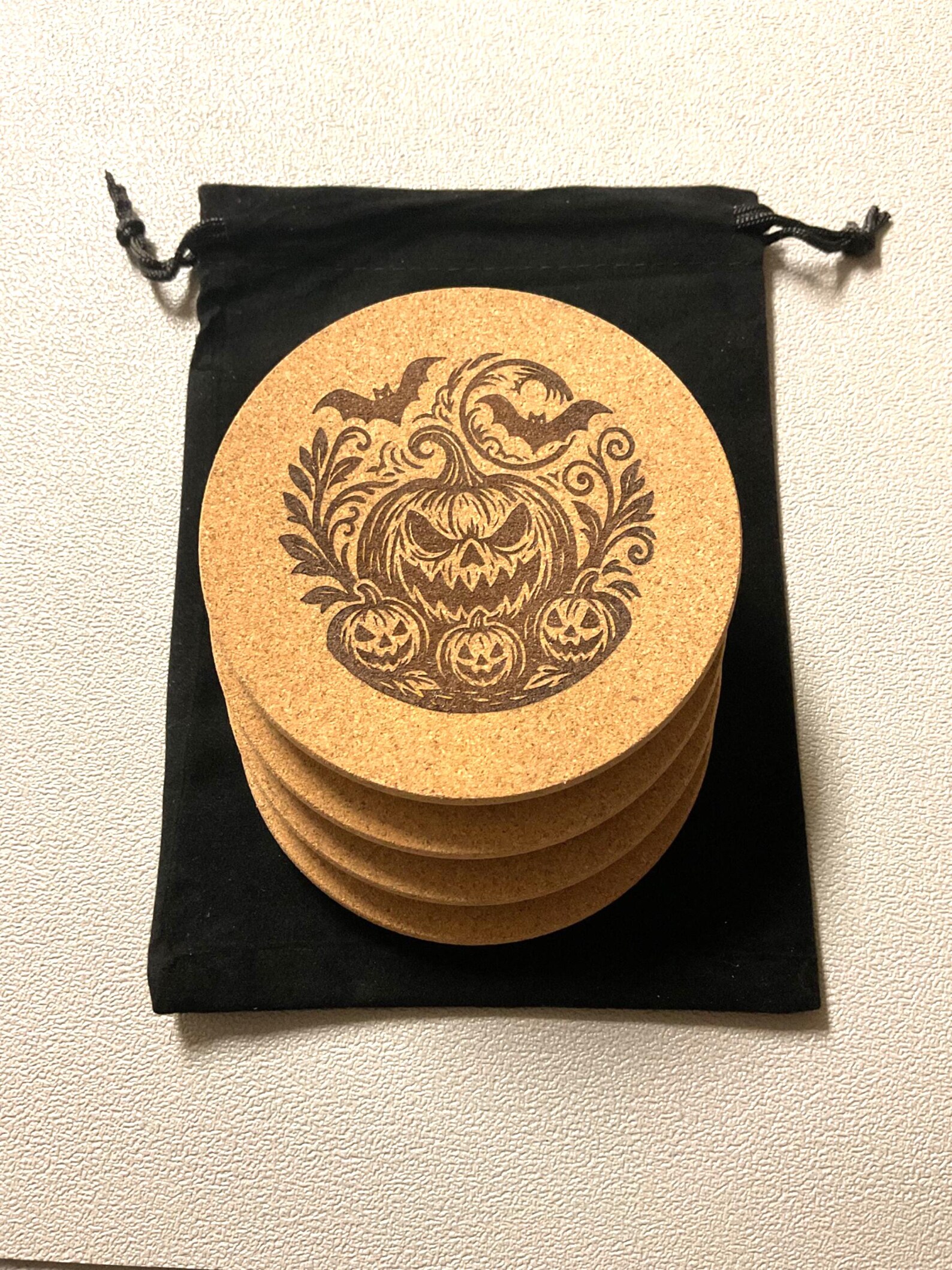 Set of four cork coasters laser etched with spooky pumpkin Halloween designs from the Robert Anthony Art studio