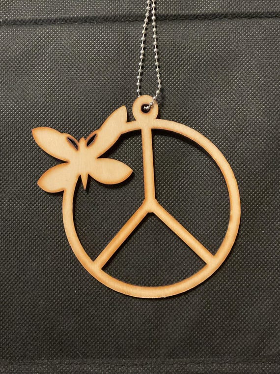 Two unfinished laser-cut basswood ornaments with a butterfly above a peace sign