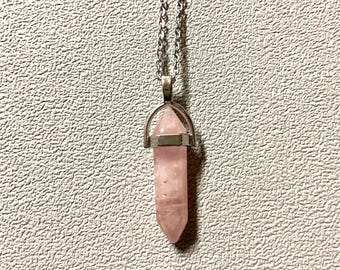 Pink rose quartz pendant hanging from a chain